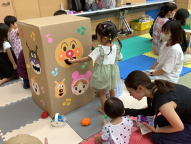 アンパンマンにおやつを食べさせる女の子の様子