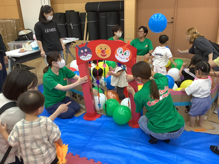 ゲートの向こうで風船プールを楽しむ子どもの様子