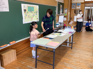 イラストを指しながら見つけたことを話す女の子