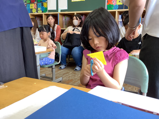 折り紙を切る女の子