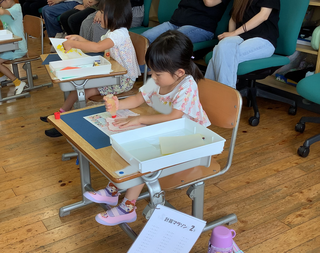 作品を台紙に貼る女の子