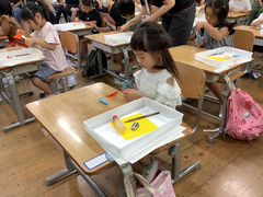 ハサミで折り紙を切る女の子