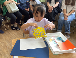 折り紙を広げてみる女の子