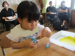 折り紙を切る女の子