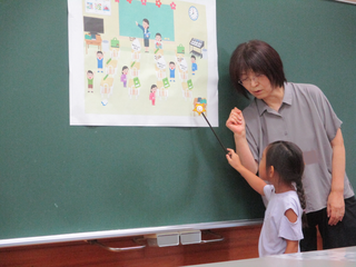 イラストを指して見つけたことを伝える女の子