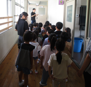 先生に学校を案内してもらうこどもたち